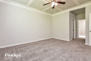 Covington house for rent - a living room with carpet and a ceiling fan