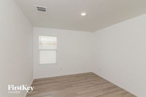 San Antonio house for rent - a bedroom with white walls and wood flooring and a window