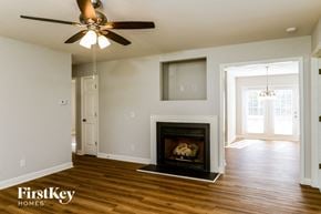 Graham house for rent - A living room with a fireplace and a ceiling fan.