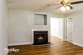 Graham house for rent - A living room with a fireplace and a ceiling fan.