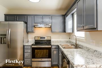 Graham house for rent - A kitchen with a stainless steel refrigerator and a marble countertop.