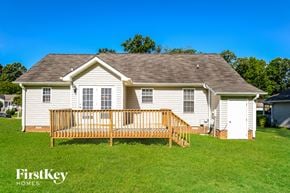 Graham house for rent - A house with a white exterior and a brown roof with a deck in front.