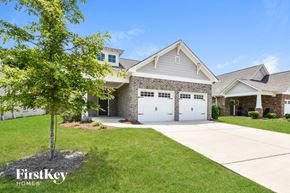 Gardendale house for rent - a house with a white garage door and a tree in the yard