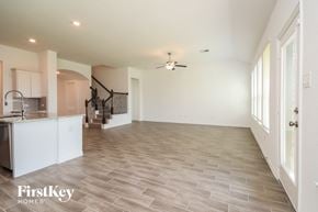 Mont Belvieu house for rent - A spacious room with a staircase and a ceiling fan.