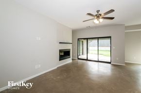 Edmond house for rent - A spacious room with a ceiling fan and a fireplace.