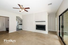 Edmond house for rent - A spacious living room with a fireplace and a ceiling fan.