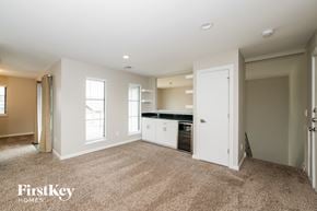 Edmond house for rent - A spacious, empty room with a kitchenette in the corner.