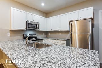 Birmingham house for rent - a kitchen with a granite counter top and stainless steel refrigerator