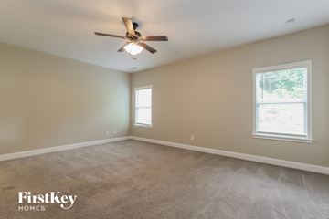 Gainesville house for rent - a living room with carpet and a ceiling fan