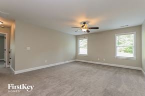 Gainesville house for rent - the master bedroom has a carpeted floor and a ceiling fan