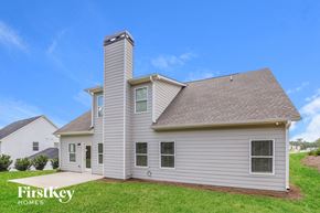 Gainesville house for rent - side view of home with white siding and green grass and a blue sky