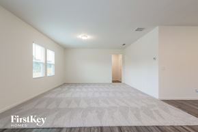 Winder house for rent - A spacious room with a rug on the floor and a door on the right side.