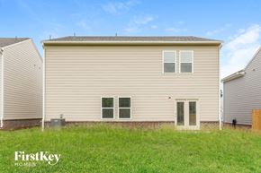 Winder house for rent - A beige house with a brown door and two windows is surrounded by a grassy area.