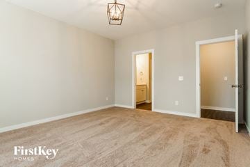 Cullman house for rent - a spacious living room with carpet and a door to the bathroom