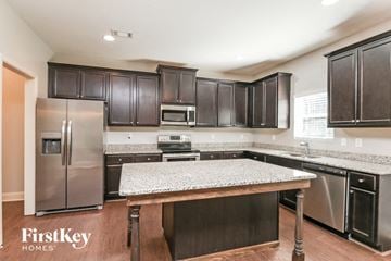 Hoschton house for rent - a kitchen with stainless steel appliances and granite counter tops