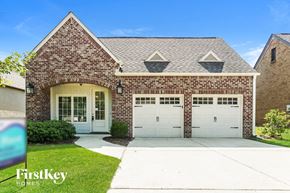 Trussville house for rent - a brick house with white garage doors and a lawn