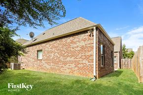 Trussville house for rent - the view of the back of a brick house with a yard and grass