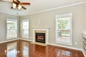 Clarksville house for rent - A spacious living room with a fireplace and a ceiling fan.