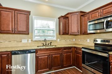 Clarksville house for rent - A kitchen with brown cabinets and a stainless steel dishwasher.