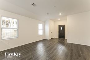 Hockley house for rent - A spacious room with wooden flooring and a black door.