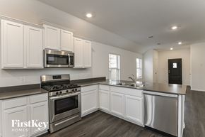 Hockley house for rent - A kitchen with white cabinets and stainless steel appliances.