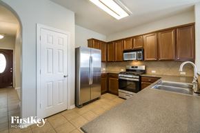 Pearland house for rent - a kitchen with stainless steel appliances and wooden cabinets