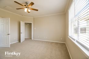 Pearland house for rent - a bedroom with a large window and a ceiling fan