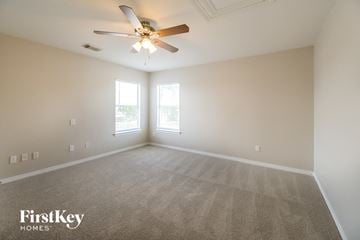 Pearland house for rent - a living room with carpet and a ceiling fan