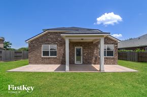 Pearland house for rent - a small brick house with a porch and a grassy yard