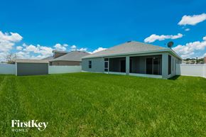 Lakeland house for rent - A house with a grey roof and a satellite dish on the roof is surrounded by a grassy lawn.