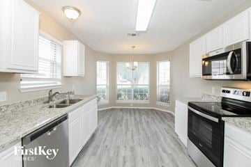 Fort Worth house for rent - A kitchen with white cabinets and a granite countertop.