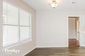 Magnolia house for rent - A room with wooden floors and a window with blinds.