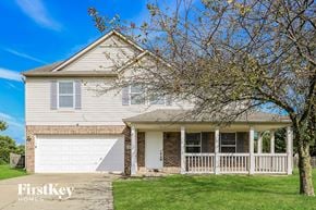 Brownsburg house for rent - A house with a garage and a tree in front of it.