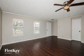 Brownsburg house for rent - A room with a ceiling fan and wooden floors.