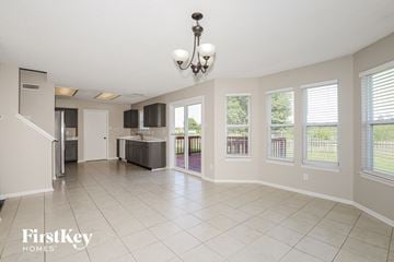 Brownsburg house for rent - A spacious living room with a kitchen in the background and a chandelier hanging from the ceiling.