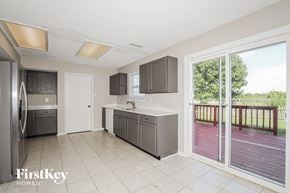 Brownsburg house for rent - A kitchen with a refrigerator, sink, and cabinets.