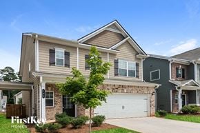 Acworth house for rent - A house with a garage and a tree in front of it.