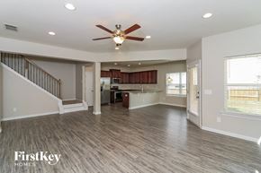 Acworth house for rent - A spacious living room with a staircase and a ceiling fan.