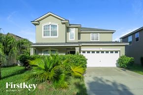 Jacksonville house for rent - a house with a garage and palm trees in front of it