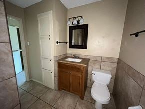 Bay City house for rent - A bathroom with a toilet, sink, and mirror.