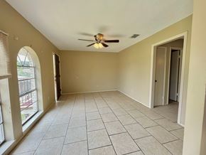 Bay City house for rent - an empty living room with a ceiling fan and a window