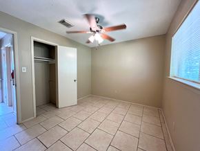 Bay City house for rent - an empty living room with a ceiling fan and tiled floors