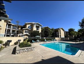 Claremont multi-family for rent - A swimming pool in front of a residential building.