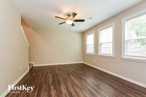 Canton house for rent - an empty living room with a ceiling fan and three windows