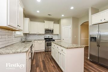 Canton house for rent - a kitchen with white cabinets and stainless steel appliances
