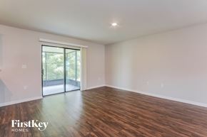 Deltona house for rent - A room with wooden floors and a sliding glass door.