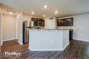 Deltona house for rent - A kitchen with a white island in the middle and wooden floors.