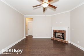 Gardendale house for rent - a empty living room with a ceiling fan and a fireplace