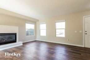 Parker house for rent - A spacious room with a fireplace and wooden floors.