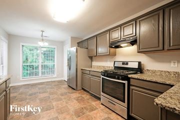 Suwanee house for rent - A kitchen with a tile floor and a window with blinds.